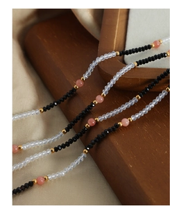 Detailed macro view of handmade beaded necklace with faceted pink and black stones
