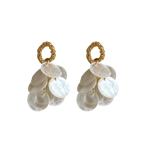 Elegant gold round earrings with white shell tassel sequins in a minimalist vacation style