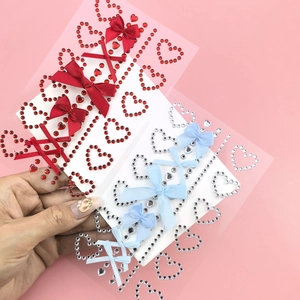 Macro detail of heart-shaped crystal rhinestones and fabric butterfly bows for facial makeup