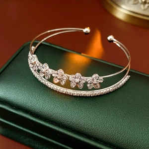 Détail d'un bracelet double couche argenté avec motifs de fleurs en zircone
