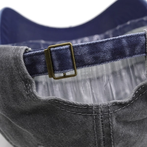 Detail of vintage washed baseball cap showing brass buckle and blue adjustable strap