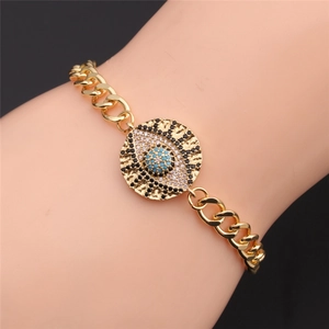 Dettaglio del bracciale Evil Eye dorato con pavé di zirconi blu e bianchi al polso