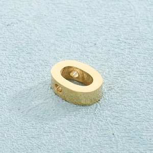Macro view of gold stainless steel oval pendant with dual hole design and polished finish