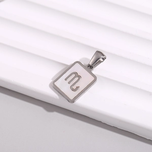 Detail of square stainless steel necklace with Scorpio sign on white mother of pearl