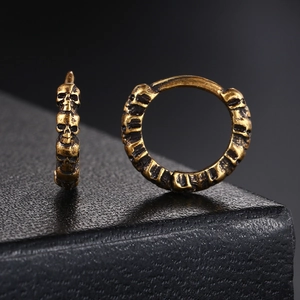 Close-up of vintage gold skull hoop earrings with retro punk and hip-hop design details