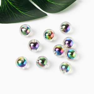 Rainbow acrylic beads with metallic glow on white background with green leaf decoration