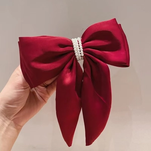 Elegant red satin bow hair clip featuring three rows of white pearls for women hair styling