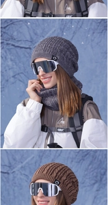 Detail of cable knit beanie and neck warmer set with professional ski goggles on snow jacket