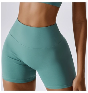 Detail of high-waist teal yoga shorts showing seamless stitching and matte compression fabric