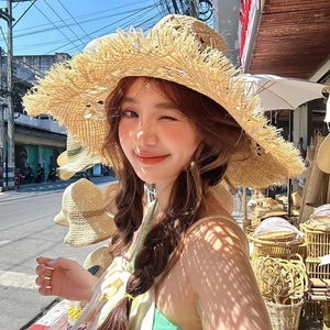 Handwoven raffia straw sun hat with large brim and frayed edges for summer beach vacation