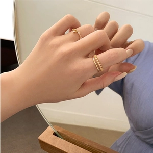 Detail of double-layer gold plated S925 silver rings with zircon stones on model hand