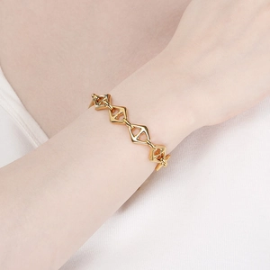 Nahaufnahme des goldenen geometrischen Schweinenasen-Gliedarmbands am Handgelenk