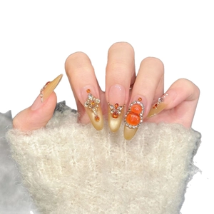 Handmade press-on nails with champagne cat eye base, amber gems, and gold floral relief