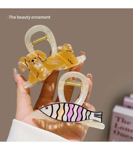 Detail of cute dog and fish shaped cellulose acetate hair claws with pearlescent finish