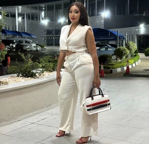 Detalle de conjunto blanco con chaleco sin mangas y pantalones de pierna ancha de tiro alto