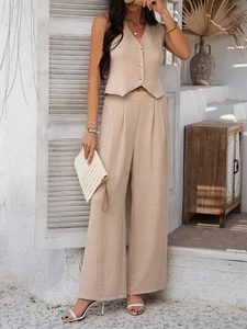Detail of beige linen-textured vest and high-waisted wide-leg pants set in soft sunlight