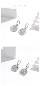 Macro shot of silver drop earrings featuring sunburst pendants with colorful zircon stones