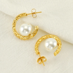 Gros plan de boucles d'oreilles perles en C dorées avec texture de métal martelé