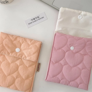 Close-up of heart-quilted sanitary storage pouch with snap closure and soft texture