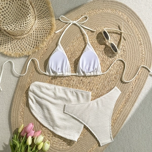 Creamy white three-piece bikini set with textured waffle fabric and matching wrap skirt
