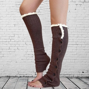 Detail of brown knit leg warmers with delicate white lace trim and black button accents