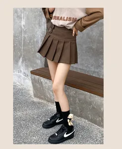 Detail of black mid-calf socks with 3D teddy bear doll and high-waisted pleated skirt