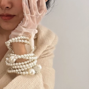 Close-up of elegant multi-layered pearl necklace with diamond-encrusted sphere details