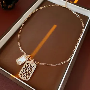 Goldhalskette mit Perlmutt-Anhänger und Zirkonia-Akzenten auf Lederhintergrund