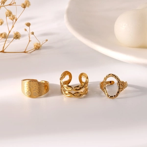 Detailed view of three gold-plated adjustable rings with hollow chain and leaf texture