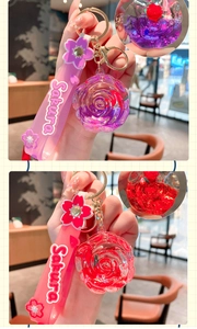 Detail of liquid rose keychain in pink and red with a Sakura rubber hand strap