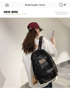 Detail view of retro denim backpack with white stitching and leather patch on a model