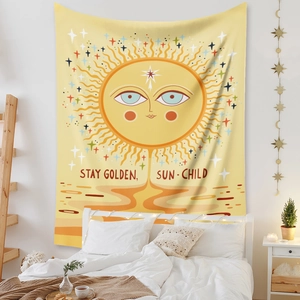 Dettaglio dell'arazzo sole bohémien con scritta Stay Golden su parete bianca