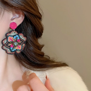 Detail of embroidered floral earrings with colorful beads in Bohemian ethnic style