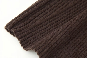 Gros plan détaillé sur la maille côtelée marron foncé montrant la texture du tissu