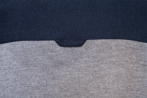 Macro view of stitching detail on navy blue and grey textured piqué fabric