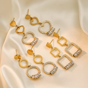 Detailed view of four pairs of gold-plated heart and geometric earrings on silk