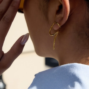 Irregular golden stainless steel ear cuff with minimalist streamlined curve design