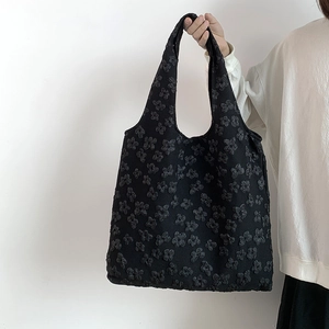 Detail shot of black 3D flower texture on lace shoulder bag with fabric relief