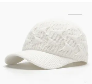 Detail showing the off-white cable knit texture and curved brim of the baseball hat