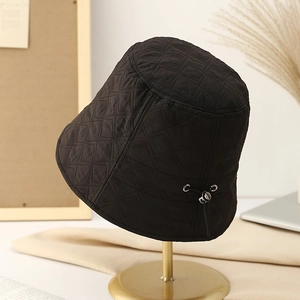 Detail of black quilted bucket hat featuring diamond stitching and adjustable drawstring