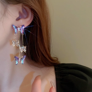 Detailed close-up of a long tassel butterfly earring with sparkling zircons on model ear