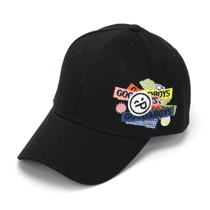Detail of colorful smiley face and Good Boys embroidery on a black cotton baseball cap