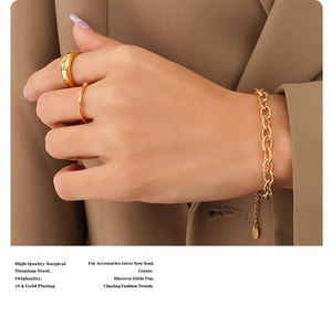 Detail of 18k gold plated titanium steel chunky chain bracelet and domed rings set