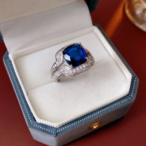 Détail macro d'une bague en zircon bleu royal avec pierres argentées dans un écrin