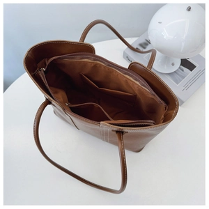 Detailed interior of the brown tote bag featuring multiple pockets and zipper closure