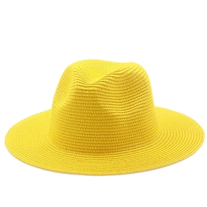 Detailed weave texture of this bright yellow straw sun hat in a classic fedora style