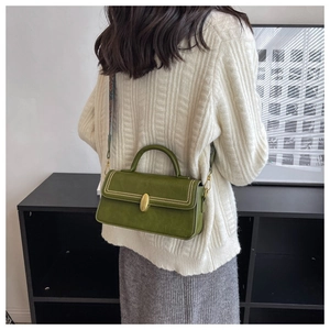 Detail view of grass green vintage crossbody bag with gold hardware and woven strap