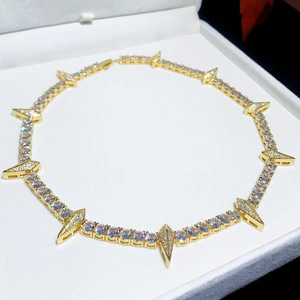 Golden 5mm tennis chain necklace with sharp spike charms in a white jewelry box