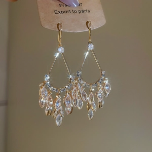 Detail of gold-plated teardrop fringe earrings with sparkling marquise-cut zircon stones