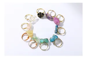 Vista superior de diez anillos de cristal natural con envoltura de alambre dorado a mano
